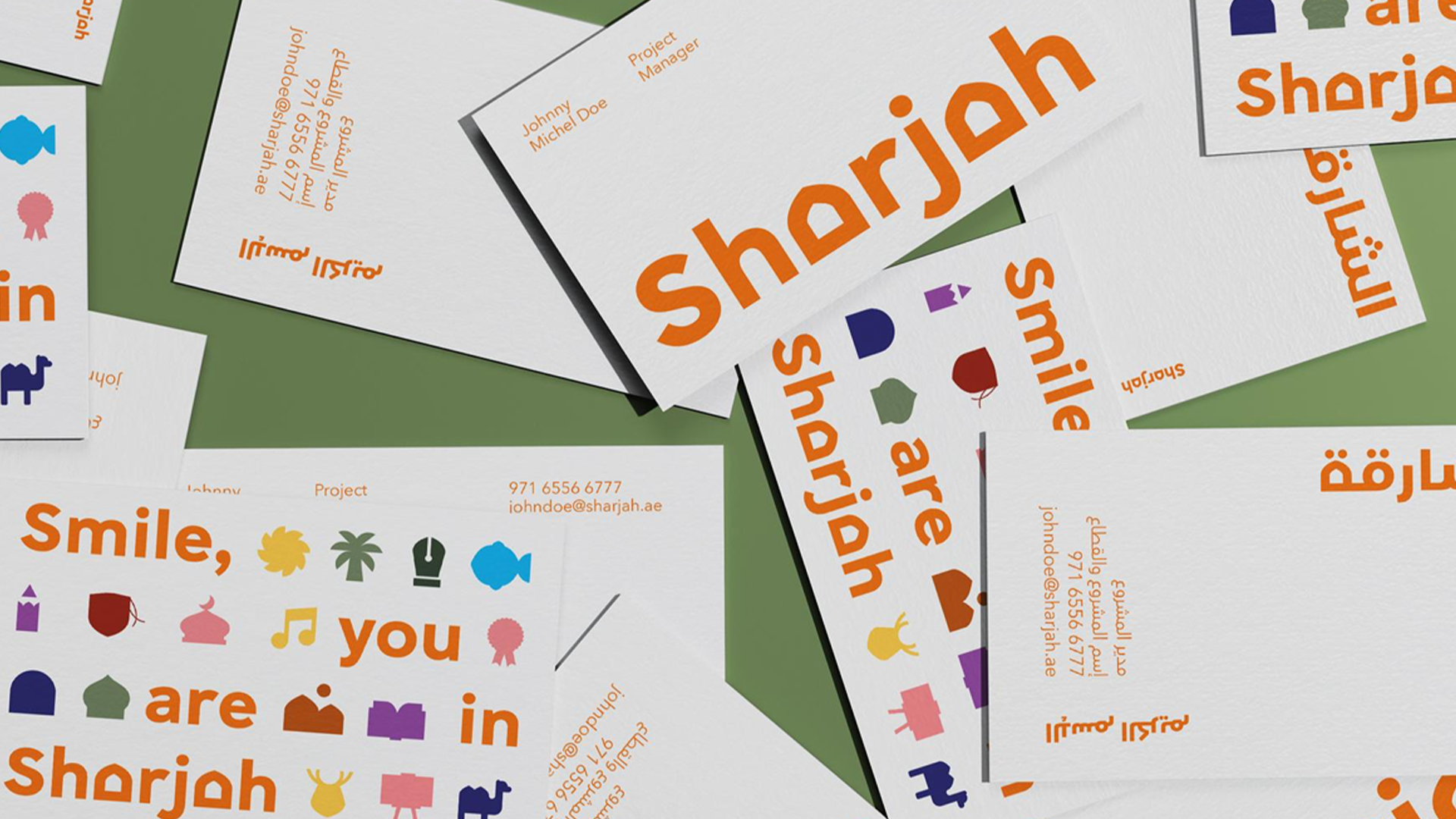 An image from a blog by Content Creatures, a creative agency specialising in video production and animation. The image features scattered business cards with colourful icons and bold orange text reading “Sharjah,” along with contact details and phrases like “Smile, you are in Sharjah” in English and Arabic.
